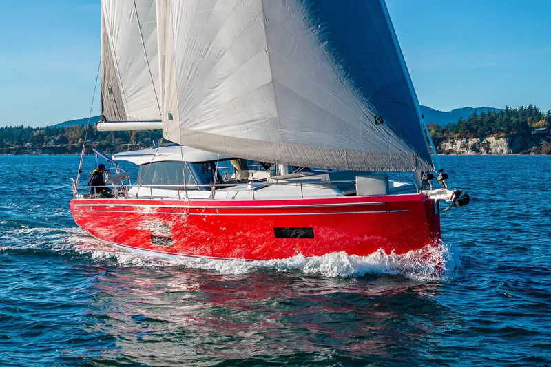 Slide: The Image of Red 2024 Moody 41ds sailboat navigating clear blue waters. - 6