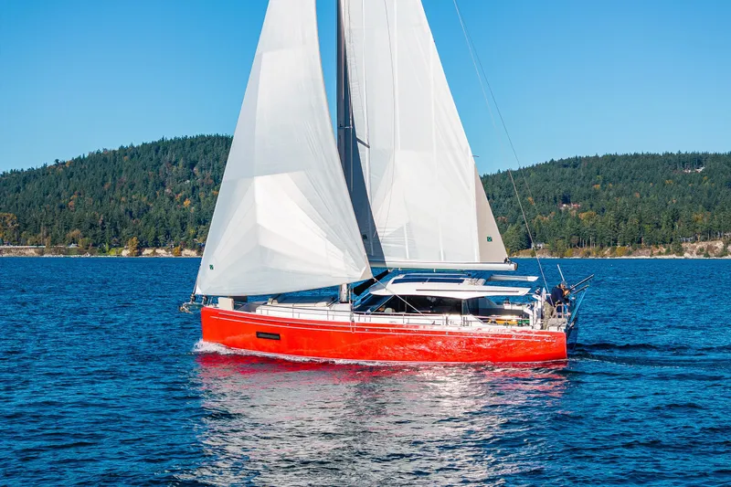 Slide: The Image of 2024 Moody 41ds sailboat with red hull sailing on a clear blue lake. - 7