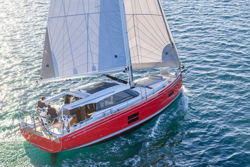Slide: The Image of 2024 Moody 41ds sailboat with red hull sailing on clear blue water. - 8