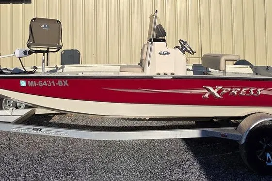 Slide: The Image of 2016 Xpress H20B Bay boat with red and white design on a trailer. - 2