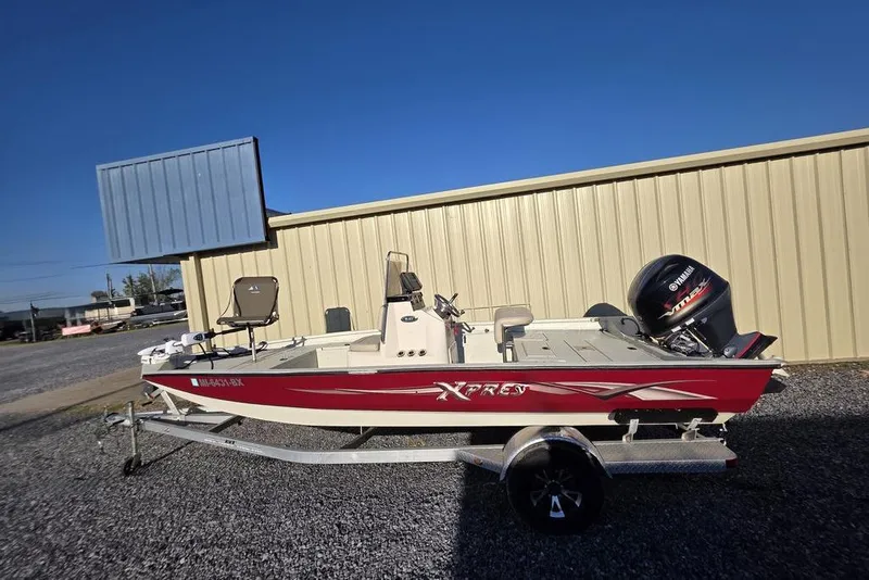 Slide: The Image of 2016 Xpress H20B Bay boat with Yamaha engine on trailer, parked outdoors. - 22