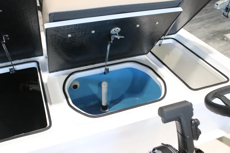 Slide: The Image of 2026 East Cape Vantage boat storage compartments with open lids and blue interior. - 12