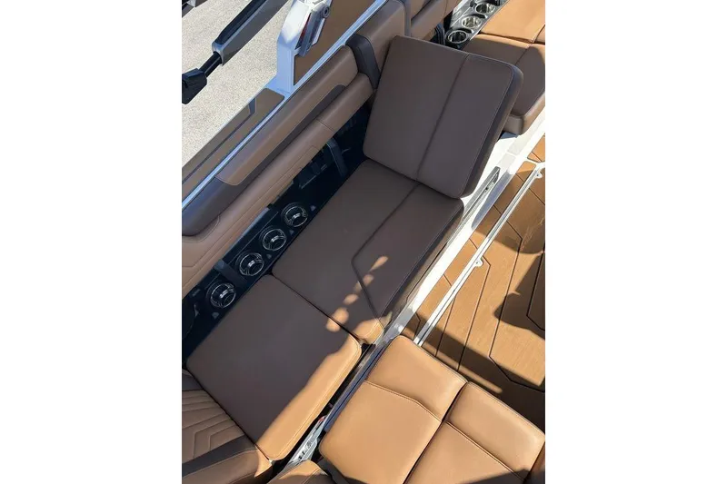 Slide: The Image of 2026 Malibu Sunscape 25 LSV boat interior with brown leather seating and cup holders. - 12