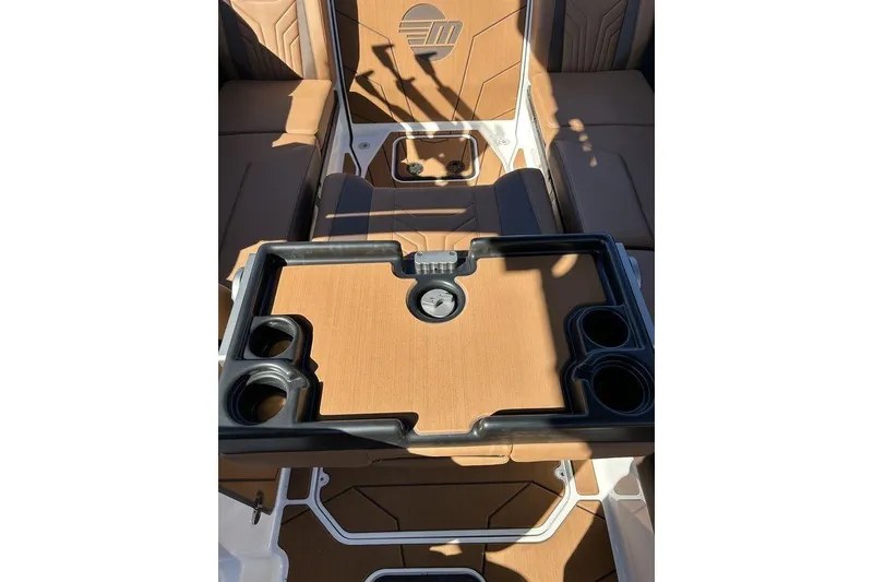 Slide: The Image of 2026 Malibu Sunscape 25 LSV interior with tan seating and black cup holders. - 14