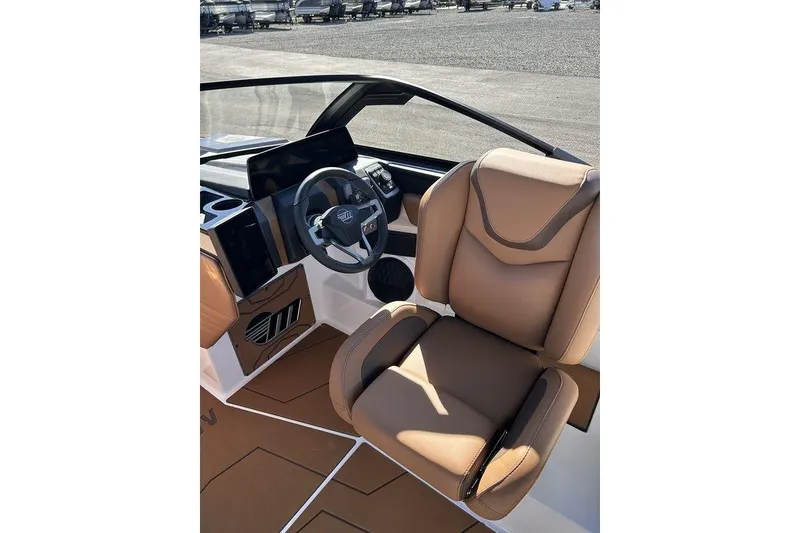 Slide: The Image of 2026 Malibu Sunscape 25 LSV boat interior with tan leather seating and modern dashboard. - 17