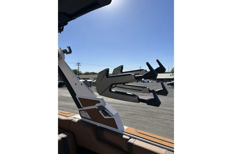 Slide: The Image of 2026 Malibu Sunscape 25 LSV boat with wakeboard rack under clear blue sky. - 20