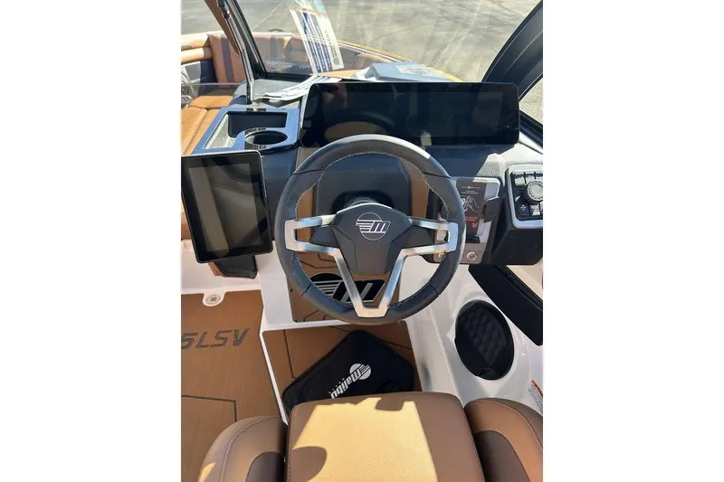 Slide: The Image of 2026 Malibu Sunscape 25 LSV boat dashboard with modern steering and digital displays. - 21