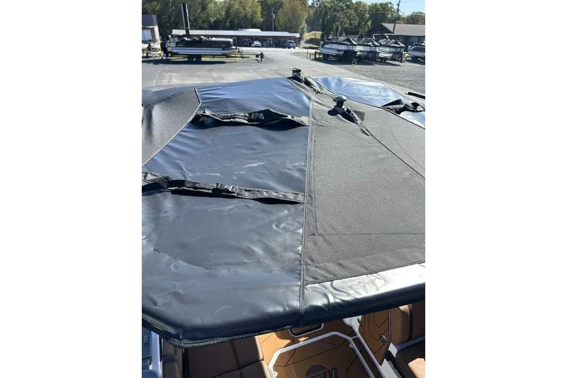 Slide: The Image of 2026 Malibu Sunscape 25 LSV boat with black canopy cover, outdoor setting. - 28