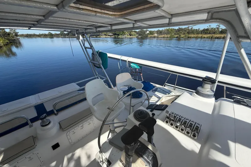 Slide: The Image of 1995 Manta Sailing Catamaran cockpit with steering wheel, controls, and serene water view. - 13
