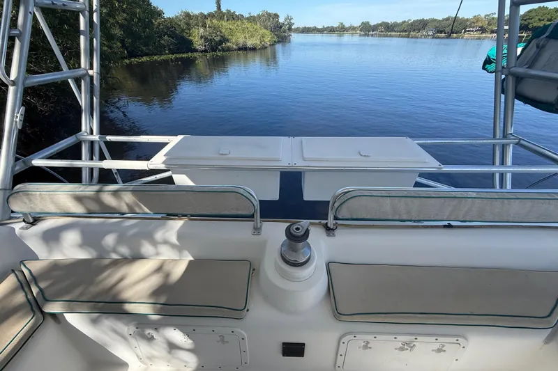 Slide: The Image of 1995 Manta SAILING CATAMARAN deck view with seating, overlooking calm water and lush greenery. - 20
