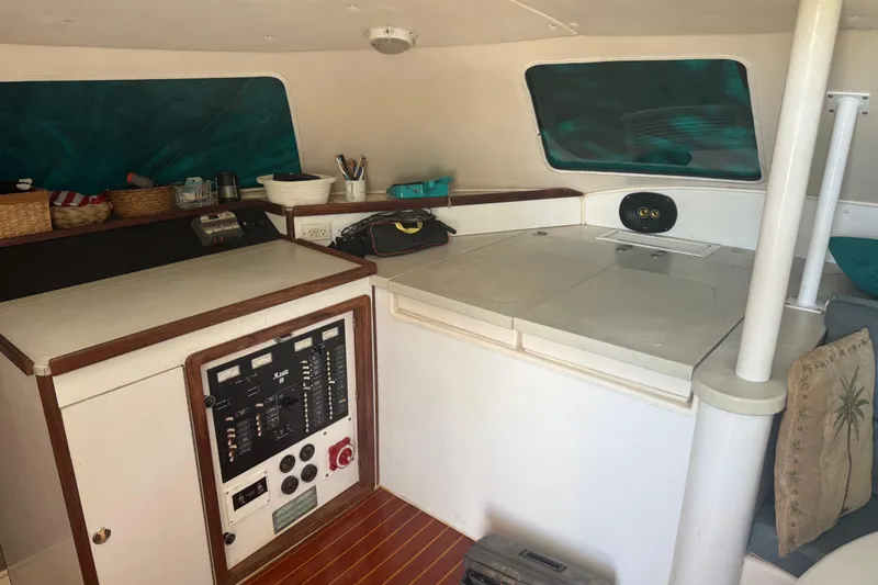Slide: The Image of Interior of a 1995 Manta Sailing Catamaran with control panel and storage area. - 25