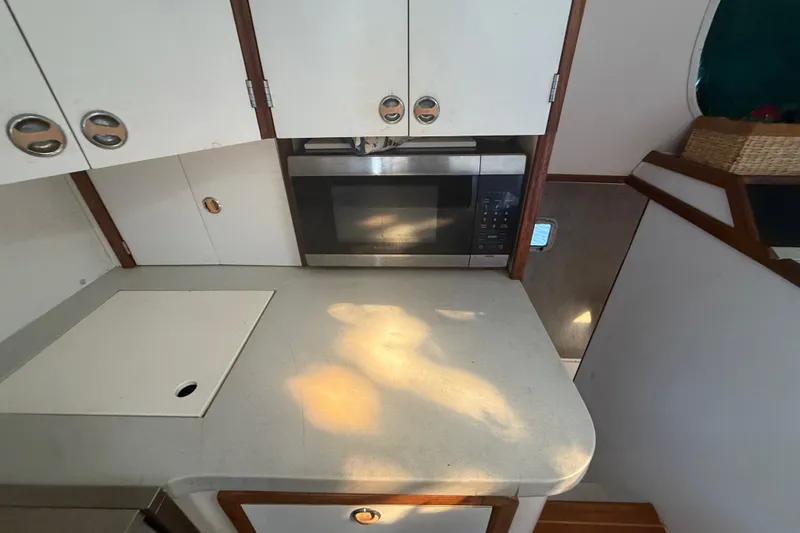 Slide: The Image of 1995 Manta SAILING CATAMARAN kitchen with microwave, white cabinets, and countertop. - 32