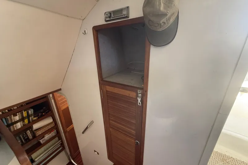 Slide: The Image of Interior of 1995 Manta Sailing Catamaran with wooden cabinet and bookshelf. - 35