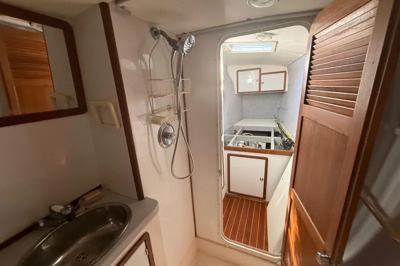 Slide: The Image of Interior of 1995 Manta Sailing Catamaran showing bathroom and cabin with wooden accents. - 36