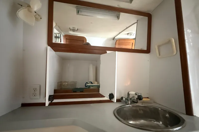 Slide: The Image of Interior of 1995 Manta Sailing Catamaran bathroom with sink, mirror, and storage cabinet. - 38