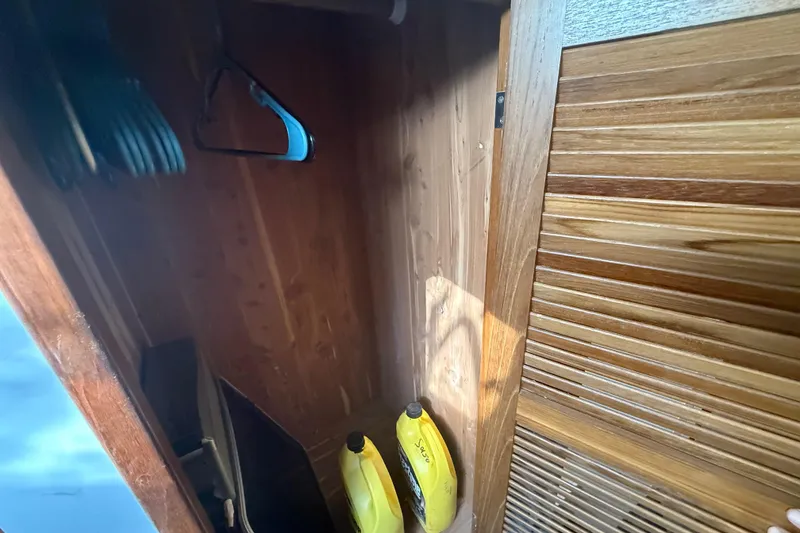 Slide: The Image of Wooden closet interior on 1995 Manta SAILING CATAMARAN with hangers and yellow bottles. - 51