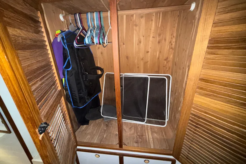 Slide: The Image of Wooden closet interior on a 1995 Manta SAILING CATAMARAN with hangers and scuba gear. - 57