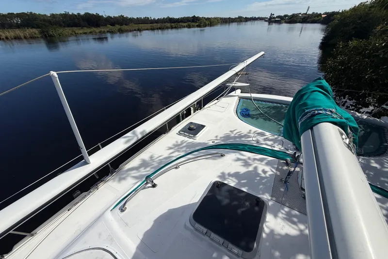 Slide: The Image of 1995 Manta SAILING CATAMARAN on calm river, surrounded by lush greenery. - 6