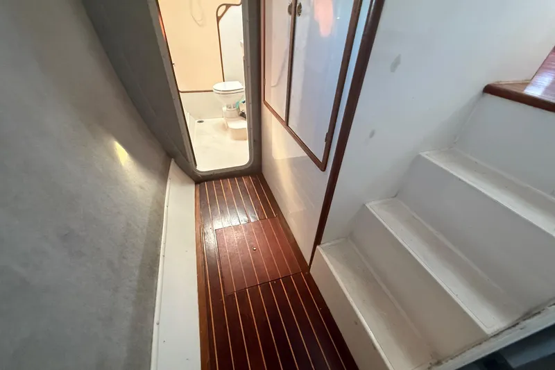 Slide: The Image of 1995 Manta SAILING CATAMARAN interior with wooden flooring and visible bathroom. - 61