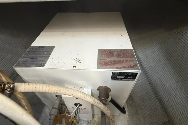 Slide: The Image of Water heater in 1995 Manta SAILING CATAMARAN, featuring caution labels and connected hoses. - 68