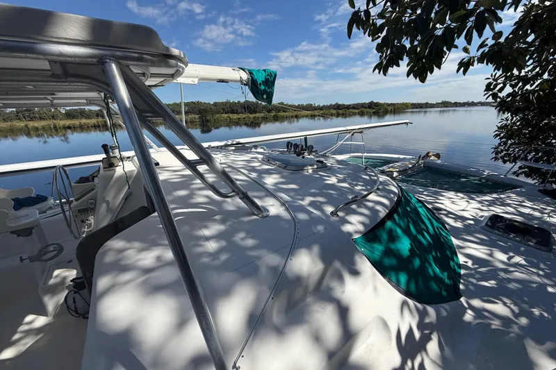 Slide: The Image of 1995 Manta Sailing Catamaran on tranquil water, surrounded by lush greenery and clear skies. - 8