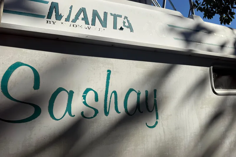 Slide: The Image of 1995 Manta SAILING CATAMARAN named "Sashay" with visible branding and shadowed exterior. - 82
