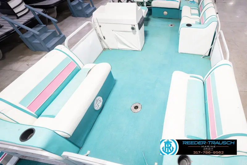 Slide: The Image of Interior of a 1993 Avalon Playbouy Challenger pontoon boat with teal and pink seating. - 11