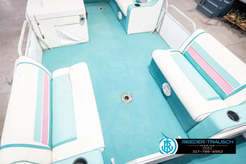 Slide: The Image of Interior of a 1993 Avalon Playbouy Challenger pontoon boat with teal and pink seating. - 12