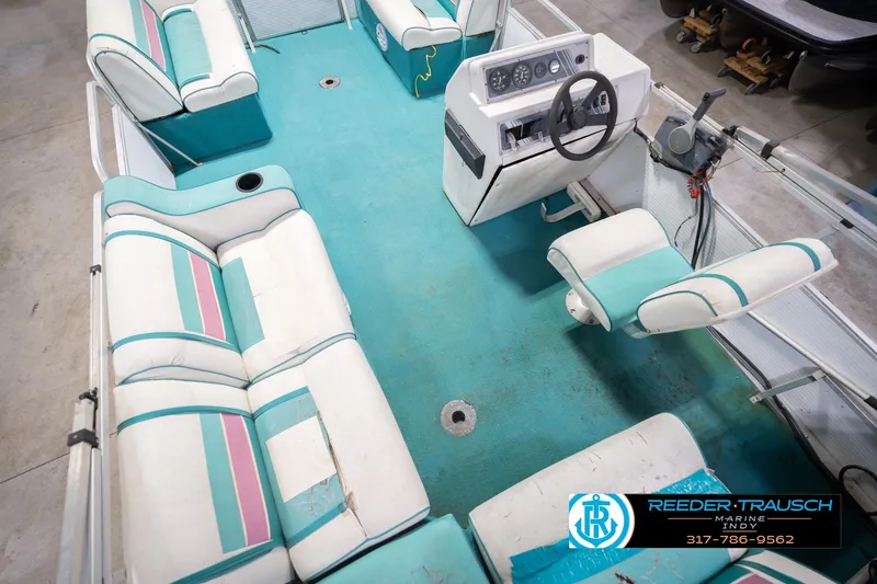 Slide: The Image of 1993 Avalon Playbouy Challenger boat interior with teal and white seating, steering console, and carpet. - 14