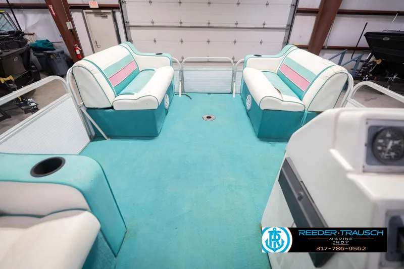 Slide: The Image of Interior of a 1993 Avalon Playbouy Challenger pontoon boat with teal and pink seating. - 19
