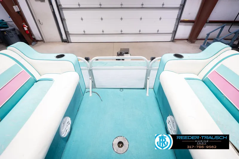 Slide: The Image of Interior of a 1993 Avalon Playbouy Challenger boat with teal and pink seating. - 20