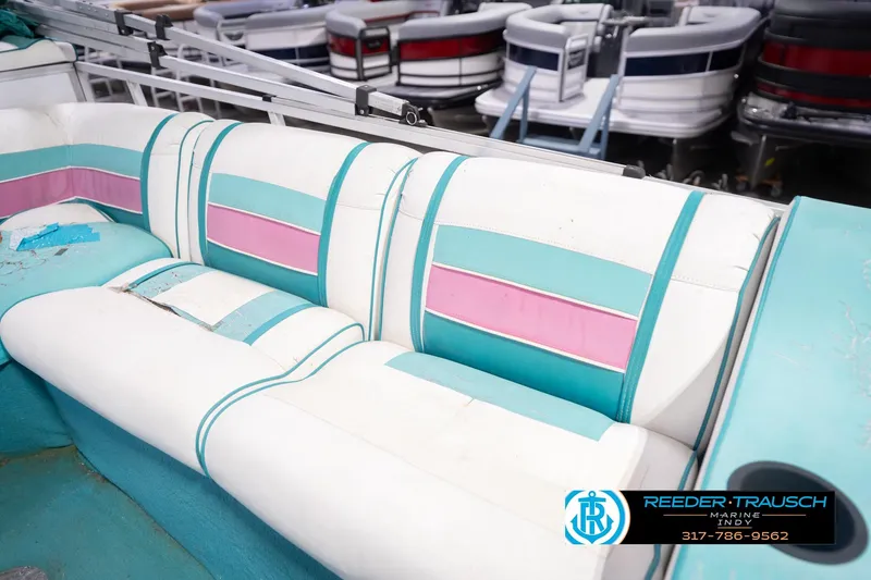 Slide: The Image of 1993 Avalon Playbouy Challenger boat interior with colorful seating, featuring teal and pink accents. - 23