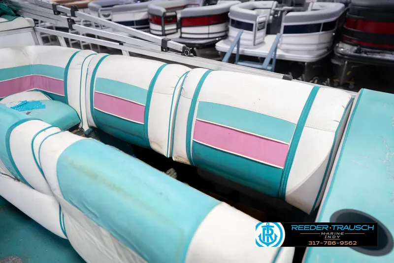 Slide: The Image of 1993 Avalon Playbouy Challenger boat interior with teal and pink seating, Reeder-Trausch Marine logo. - 24