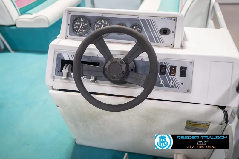 Slide: The Image of 1993 Avalon Playbouy Challenger boat dashboard with steering wheel and control panel. - 27