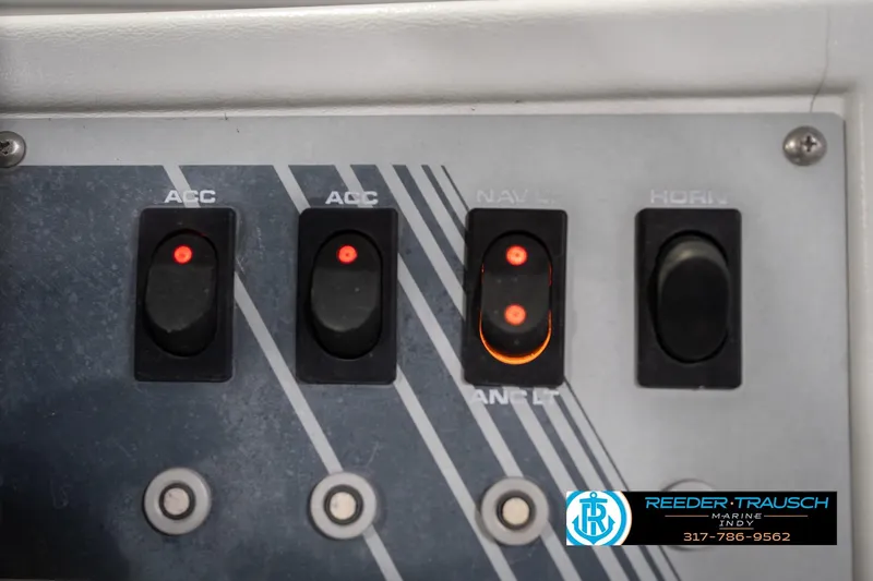 Slide: The Image of Control panel of a 1993 Avalon Playbouy Challenger boat with labeled switches. - 32