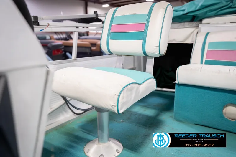 Slide: The Image of 1993 Avalon Playbouy Challenger boat seat with teal and pink accents in a showroom. - 34