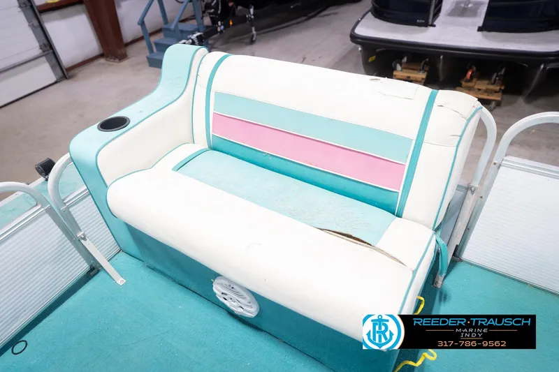 Slide: The Image of 1993 Avalon Playbouy Challenger boat seat with teal, pink, and white upholstery in a showroom. - 36
