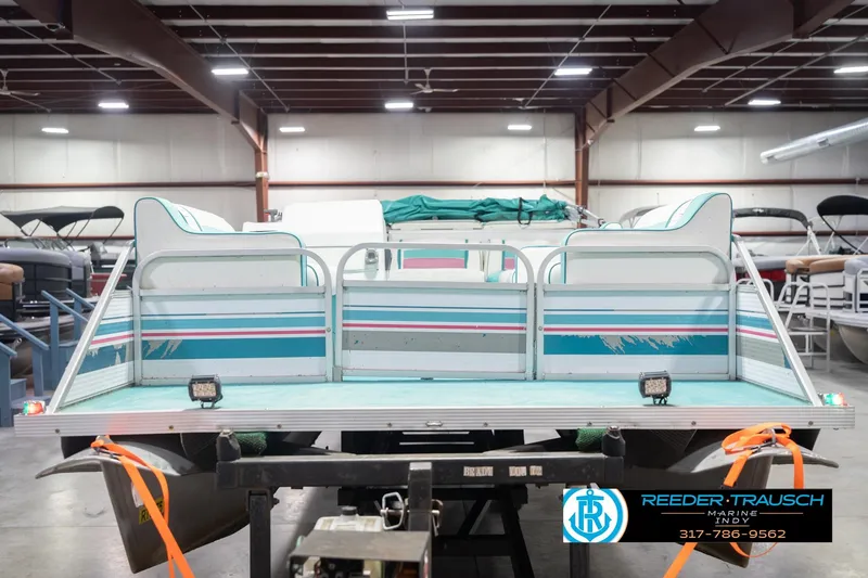 Slide: The Image of 1993 Avalon Playbouy Challenger pontoon boat in a warehouse setting. - 4
