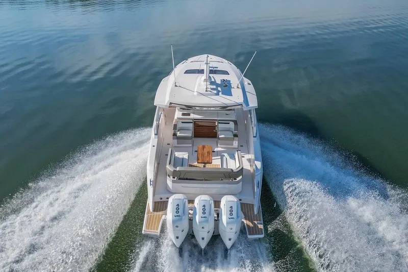 Slide: The Image of 2024 Tiara Yachts 38 LS cruising on calm water, showcasing triple outboard engines. - 10