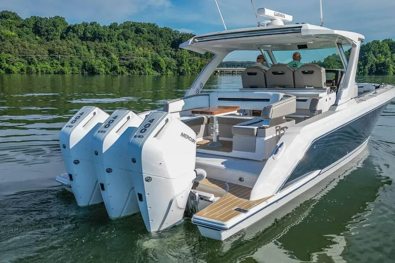 Slide: The Image of 2024 Tiara Yachts 38 LS with triple Mercury engines on a serene lake. - 12