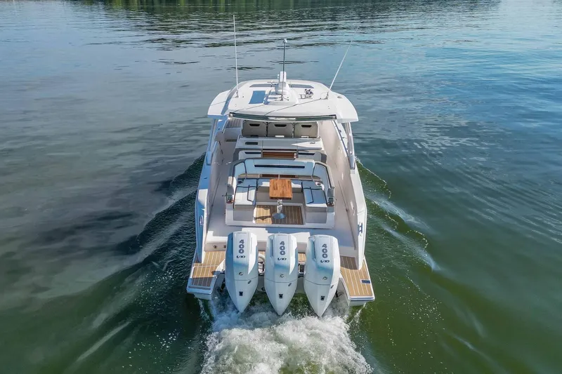 Slide: The Image of 2024 Tiara Yachts 38 LS cruising on calm water, showcasing triple outboard engines. - 13