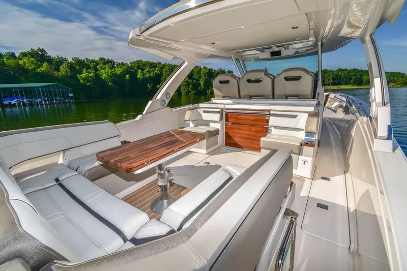 Slide: The Image of 2024 Tiara Yachts 38 LS luxury boat interior with seating and table on a sunny day. - 16