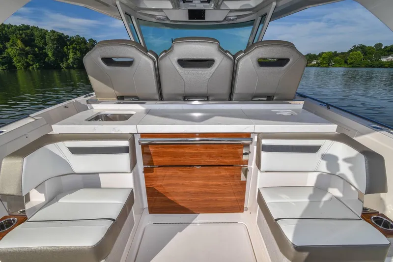 Slide: The Image of 2024 Tiara Yachts 38 LS interior with luxurious seating and sleek design on a serene lake. - 17