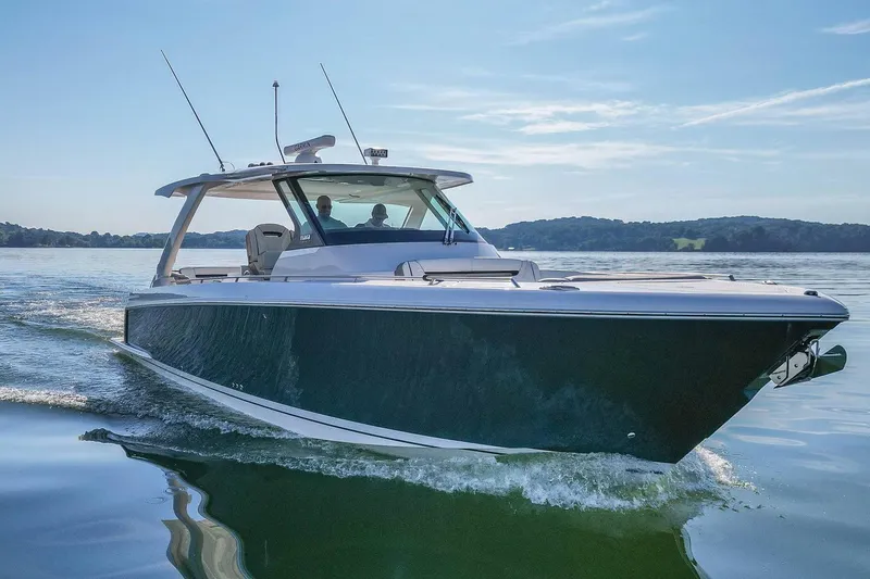 Slide: The Image of 2024 Tiara Yachts 38 LS cruising on a serene lake under a clear blue sky. - 2