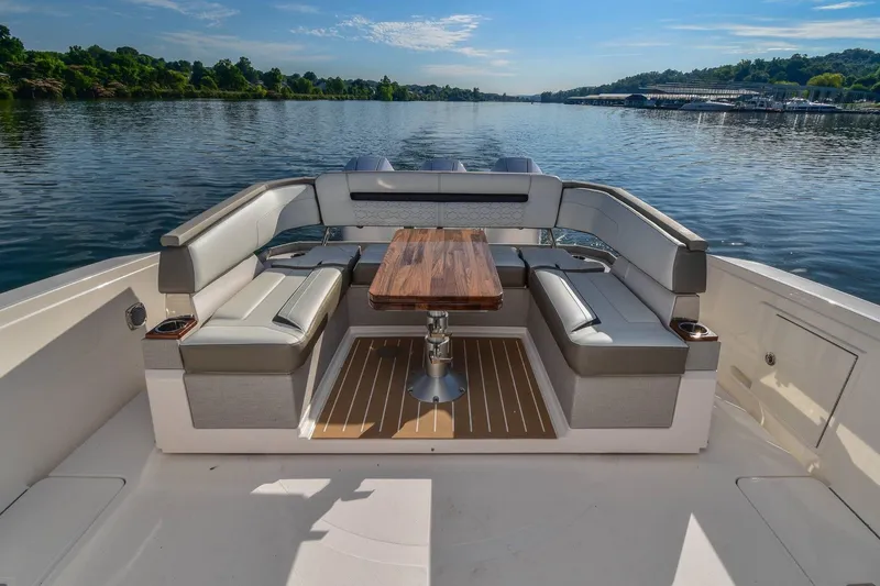 Slide: The Image of Luxurious seating area on 2024 Tiara Yachts 38 LS, overlooking serene water and lush greenery. - 25