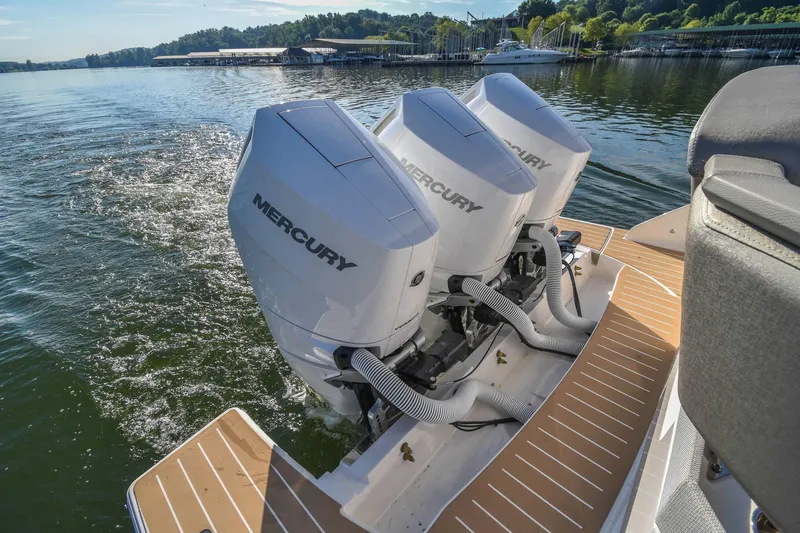 Slide: The Image of 2024 Tiara Yachts 38 LS with triple Mercury outboard engines on a serene lake. - 27