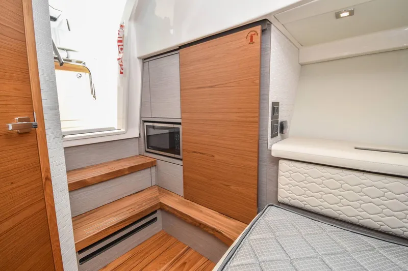 Slide: The Image of 2024 Tiara Yachts 38 LS interior with wooden steps, modern cabinetry, and cushioned seating. - 28