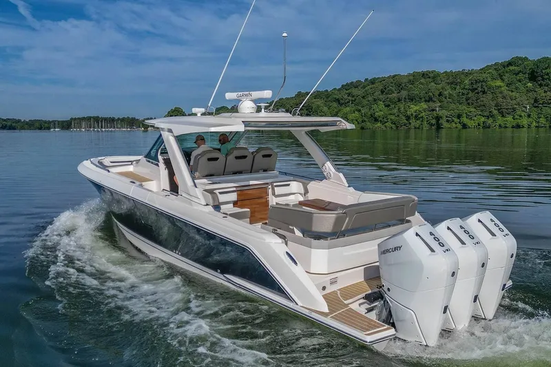 Slide: The Image of 2024 Tiara Yachts 38 LS cruising on a serene lake with triple Mercury engines. - 6