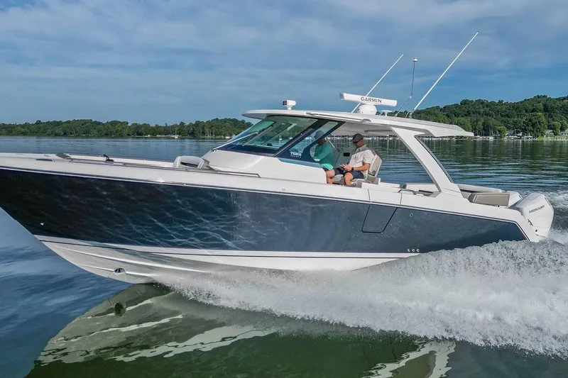 Slide: The Image of 2024 Tiara Yachts 38 LS cruising on a serene lake under a clear blue sky. - 7