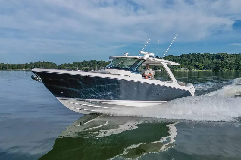 Slide: The Image of 2024 Tiara Yachts 38 LS cruising on a serene lake under a clear blue sky. - 8